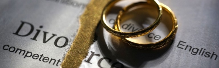 Wedding rings over a newspaper article regarding divorce.